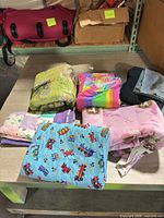 Overview of six folded blankets and sheet set on table