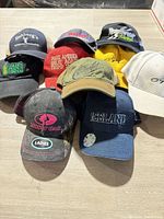 All nine hats arranged showing front logos and variety