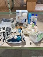 Overview of all items on table including irons, organizer, skincare, gift set, scarf and accessories