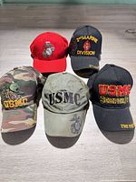 Group shot of all five USMC hats showing front designs