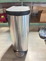 Full view of stainless steel trash can showing pedal, body and lid