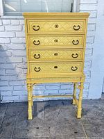 Front view of yellow four-drawer lingerie chest on stand