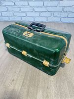 Closed green aluminum tacklebox, front view with handle and latches visible