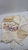 assortment of crochet lace pieces, damask napkins and ribbon trim displayed together