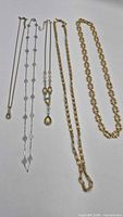 Four Avon necklaces laid out to show full length and styles