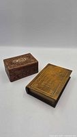 Book-shaped storage box and carved wood box side by side