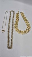 Three necklaces laid flat showing overall styles and lengths