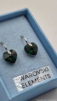 Front view of green heart Swarovski earrings in blue box