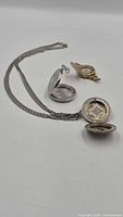 All three lockets open to show interiors and chain attached to one