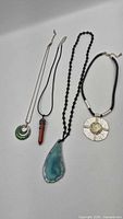 All four pendant necklaces displayed side by side