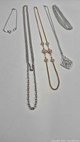 Five necklaces visible; three with distinctive pendants/stations, showing overall design and finish
