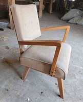 Side view of beige upholstered wooden armchair rocker