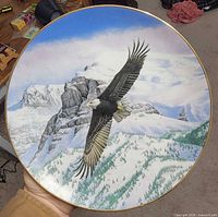 Front view showing eagle artwork, gold rim, mountainous background