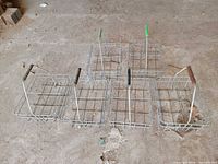 six wire milk bottle carriers standing on floor