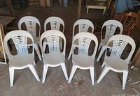 Front view of eight white plastic chairs arranged in two rows