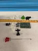 Group view of all carved stone and glass items with ruler for scale