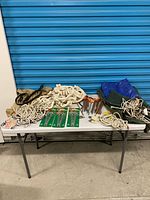 Table view of ropes, tarps, loose stakes, sealed peg packs