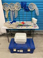 Group shot showing nets, magnifiers, pipettes, trays on table and blue Rubbermaid case