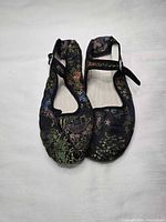 Full view of both flats showing uppers and floral embroidery