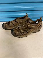 Side view of both sandals showing overall design, leather uppers, bungee laces and pull tabs