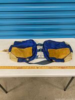 Full view of double pannier laid flat on table showing both compartments and leather panels