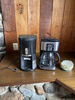 Both coffee makers and filter container on countertop