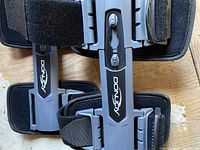 Close view of DonJoy logo on grey frame with black straps