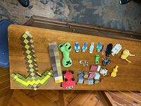 Overall lot on table showing foam sword, torch, plush, figures and blocks
