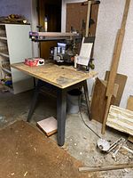 Full view of Craftsman radial arm saw on plywood table and metal stand