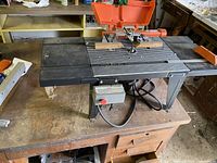Router table on workbench top showing surface, fence and power switch
