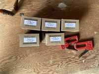 Staple boxes and one gun on plywood surface