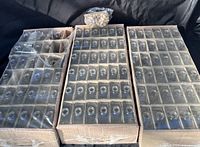 Three cartons holding rows of clear glass bottles plus bag of corks