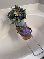 Overall view of caddy on tub holding flower arrangement and wire basket