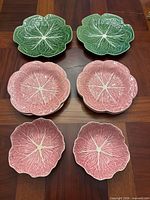 Six plates displayed: two green dinner plates, two pink salad plates, two pink bowls