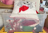 Plastic bin showing Shih Tzu pillow and assorted decor inside