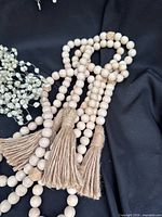 wooden bead garland with jute tassels next to pearl garland segment