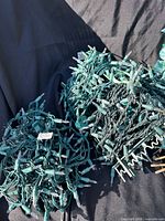 Two bundles of green-wire white bulb string lights tangled together