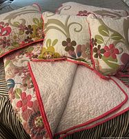 Quilt, shams and throw pillows arranged on bed showing overall pattern and items