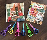 Books and six decorative edge scissors displayed on floor