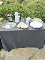 Overall shot showing French press, carafes, platters, decorative plates, bowl and jelly jar
