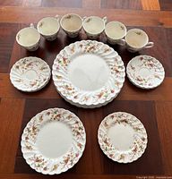 Full assortment showing six cups, stacked plates of three sizes, sample saucers