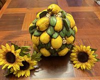 Front view of ceramic lemon cluster with three artificial sunflowers displayed