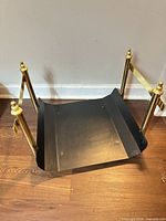 Overall view of metal log holder showing black tray and brass uprights