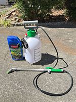 Vivosun sprayer with wand and hose alongside BioAdvanced herbicide bottle on driveway
