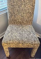 Front view of upholstered chair showing fabric pattern and upholstered legs