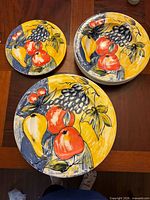 Group of dinner plates, bowls and salad plate showing fruit design