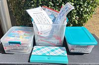 Three bins and plaid case on table, labels visible