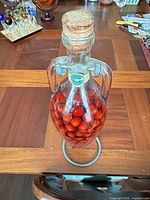 Full view of sealed cranberries bottle on metal stand