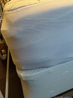 Corner of white box spring under mattress