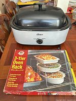 Roaster oven with lid and boxed 3-tier rack on table